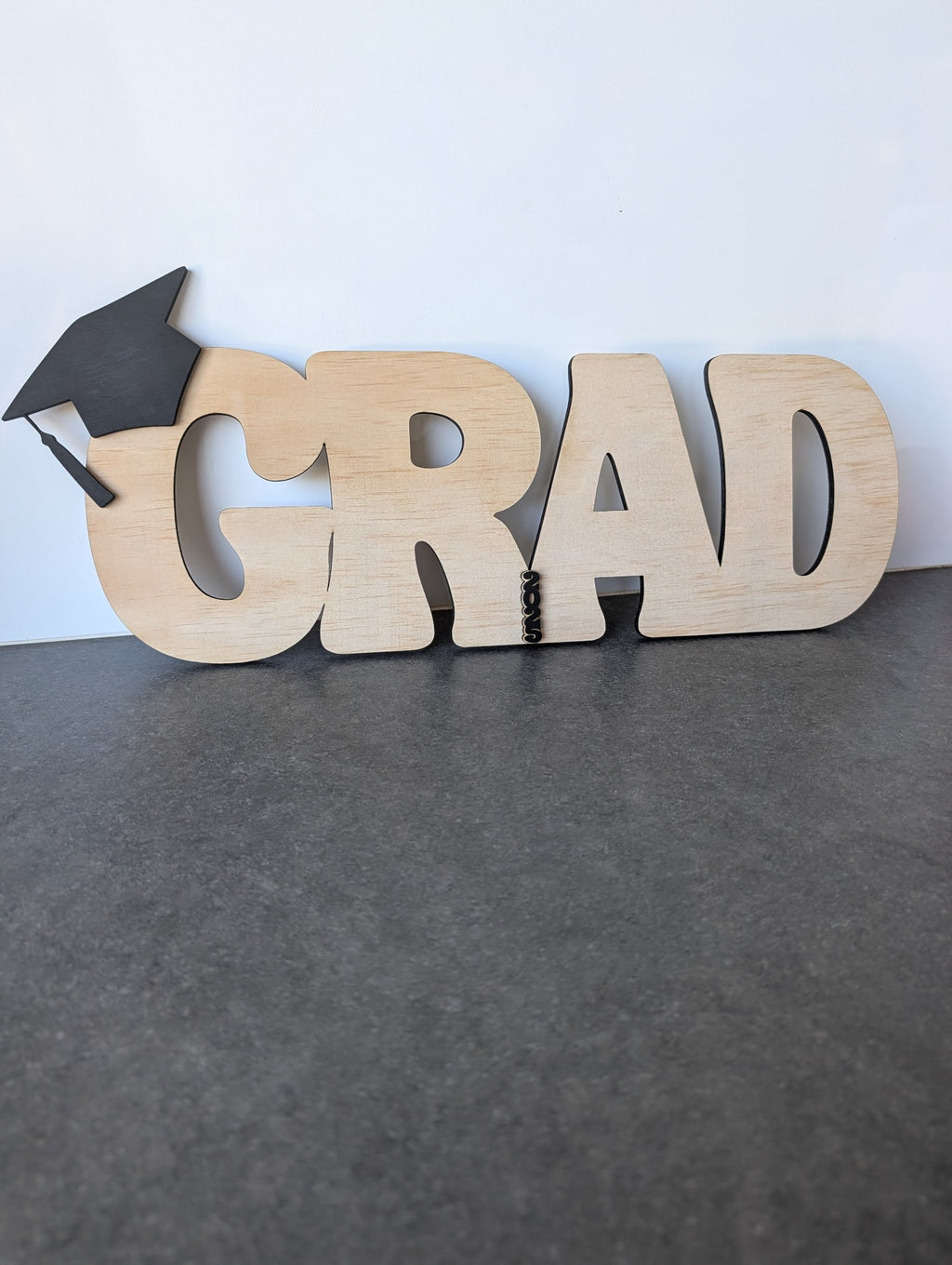 Original handmade wooden GRAD graduation sign with black cap and 2026 detail