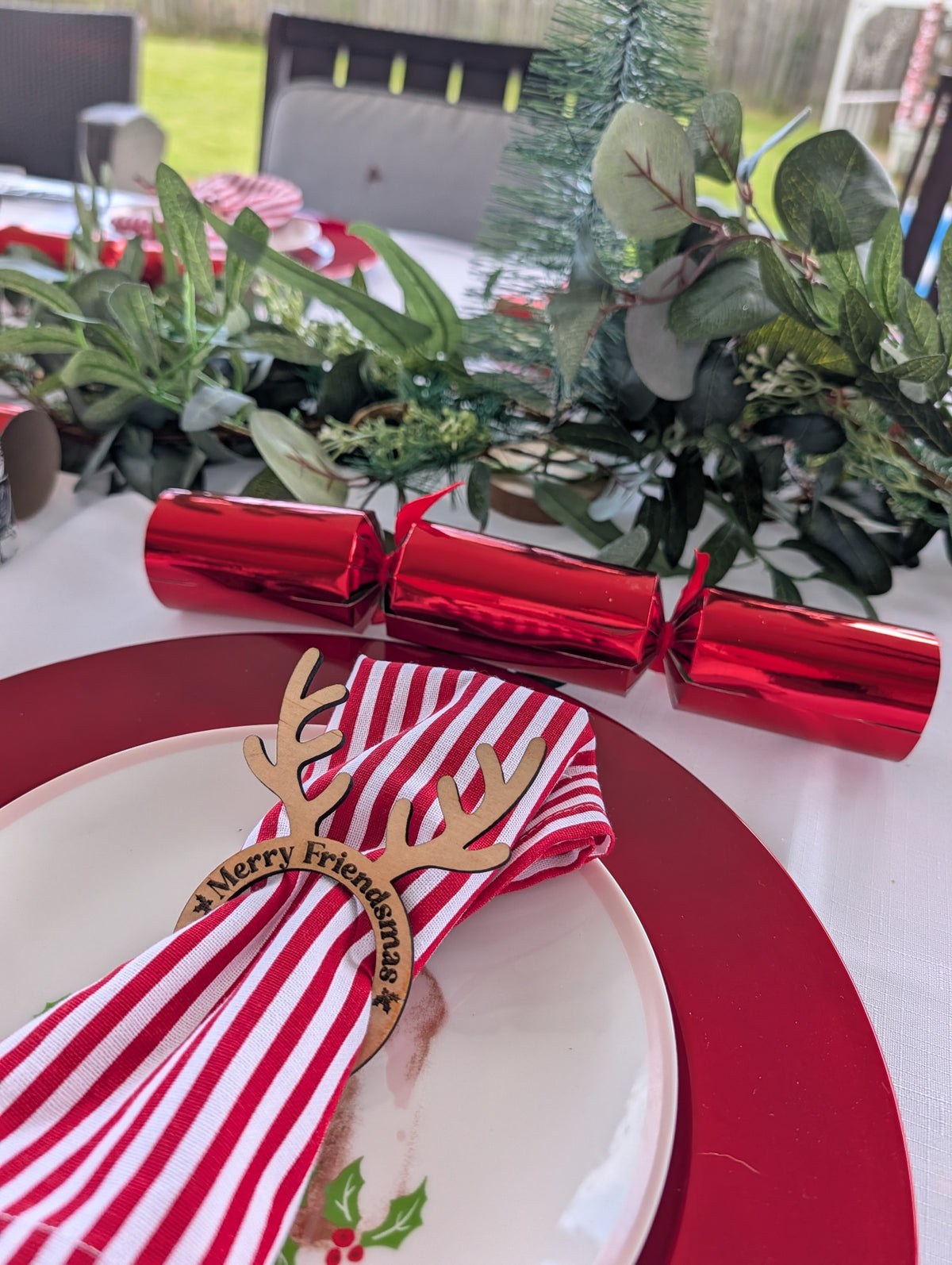 Merry Friendsmas wooden reindeer Christmas napkin ring at festive table setting