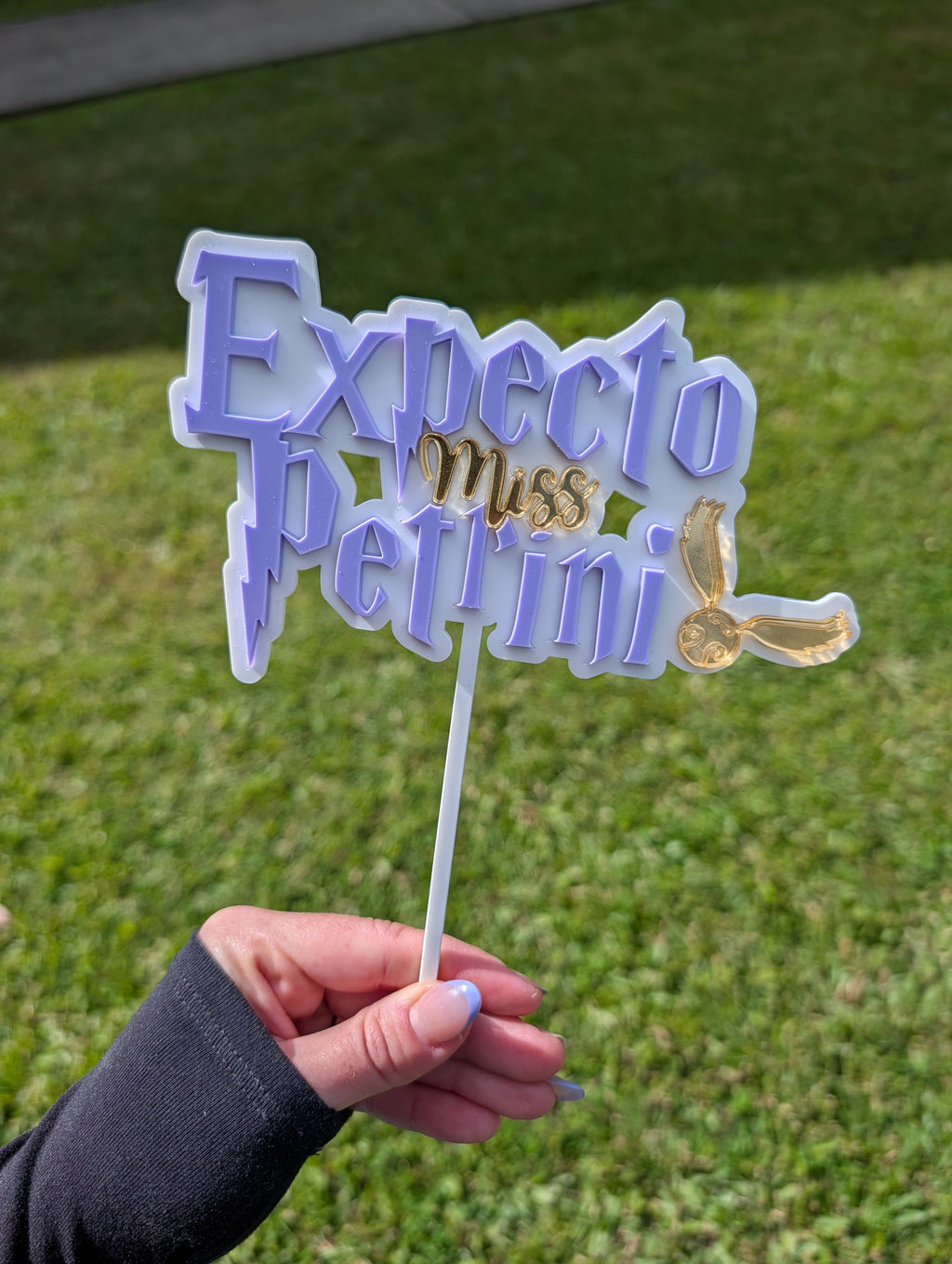 Layered acrylic baby shower cake topper displayed on a celebration cake